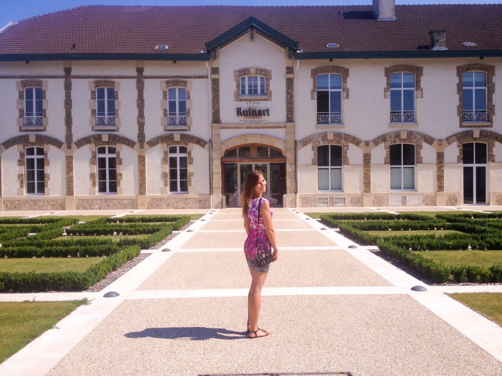 A girl standing in front of Ruinart Champagne House in France