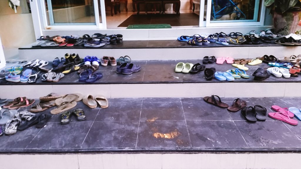 Lots of shoes and slippers outside a hotel in Thailand